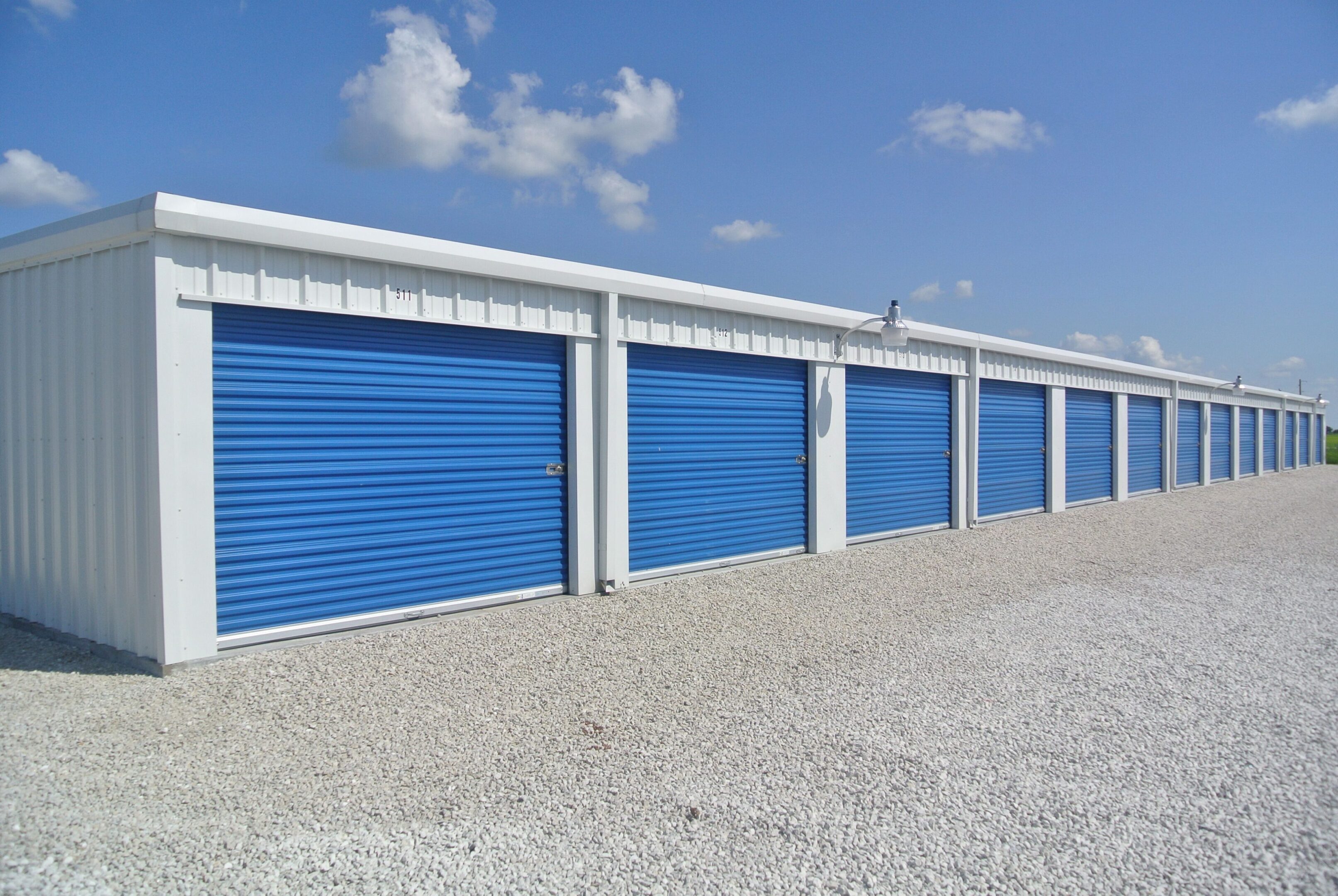 A row of blue and white storage units on the side of a road.